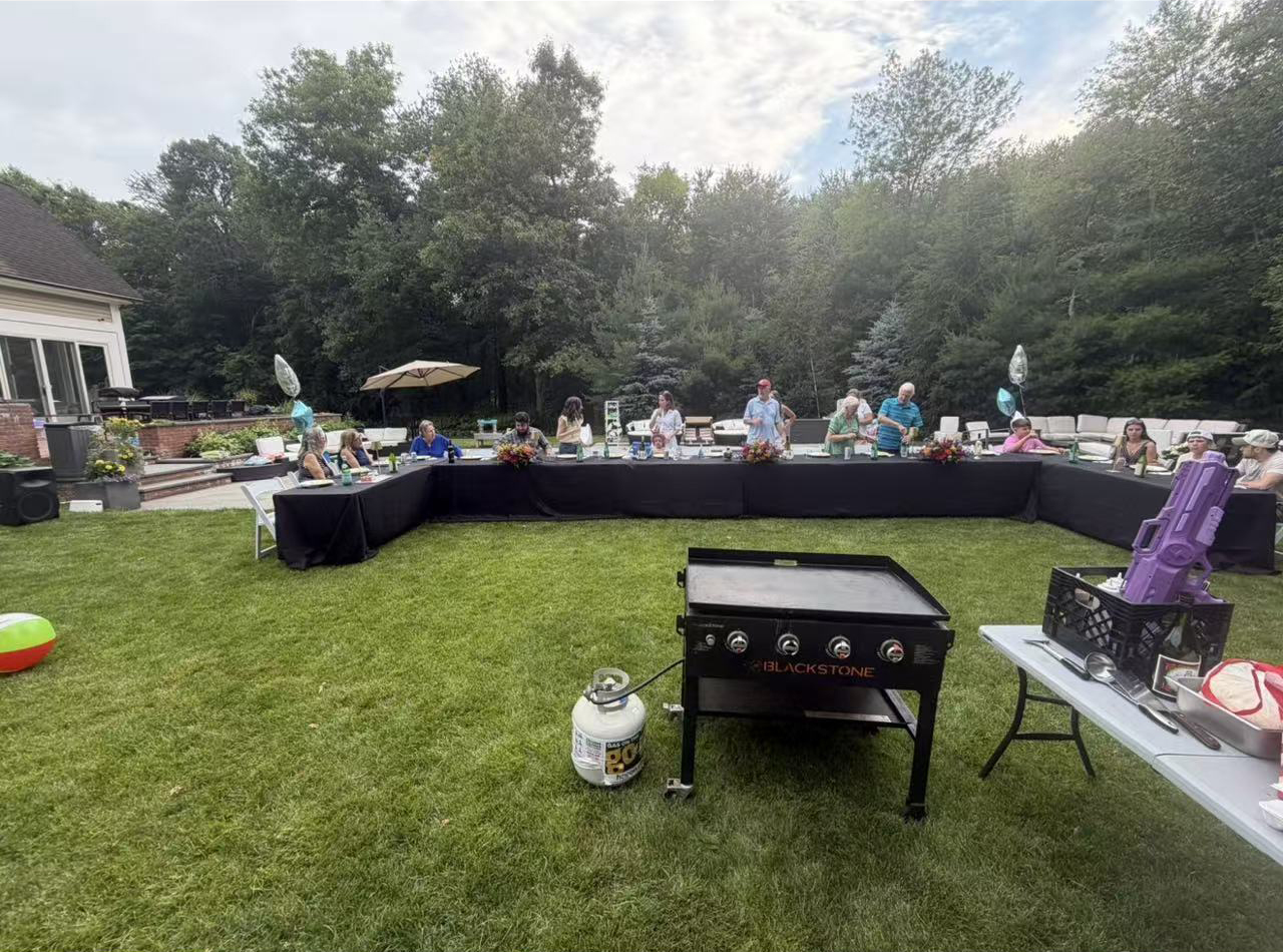 Go For Hibachi backyard party with the grill set up and guests gathered